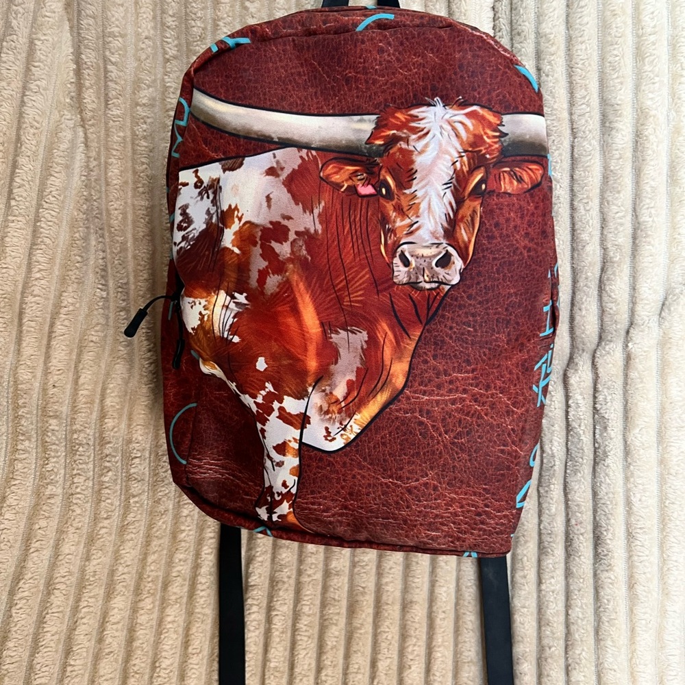 Brown Longhorn Cow Print Backpack  with blue brands on the side. Really cute